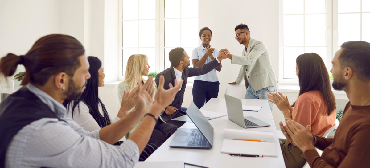 Diverse employees congratulate man on business achievements, excellent work results or promotion.